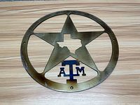 Metal oval wall decoration with star, Texas state cutout, and 'ATM' emblem for Texas A&M University.
