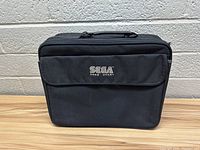 Front view of the black Sega Game Gear carrying case showing the embroidered Sega Game Gear logo on the front pocket.