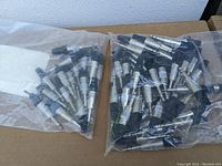 Two bags of Neutrik connectors, one bag with silver XLR type connectors and the other with metal TRS connectors with black plastic ends.