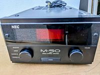 Front view of NEC M-50 amplifier showing front panel, display, source and volume knobs