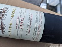 Close-up of wine bottle label showing Chateau Merlot 2002 and gift set details
