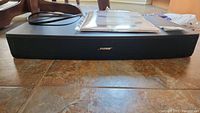Front view of the black Bose Solo TV Sound System soundbar with power cable visible behind.