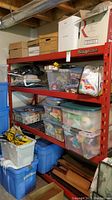 Front view of red Snap-on steel shelving loaded with bins