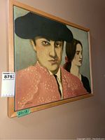 Frontal view of the framed oil painting showing matador and woman with signed artist name and frame details.