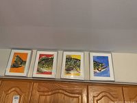 Wide shot showing all four framed paintings arranged side by side forming a fish