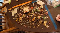 Overview of assorted costume jewelry laid out on table, including pins, bracelets, necklaces, and earrings