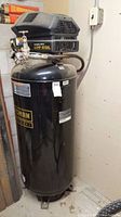 Front view of vertical compressor showing full tank, motor housing, Craftsman Professional logo