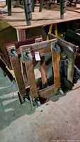 Photo showing all three flat floor dollies stacked against a wall, highlighting metal frames and caster wheels.