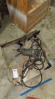 Overview photo showing Stanley woodworking planer and power tools piled on floor with cords tangled.