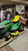 Full view of John Deere mower and Agri-Fab trailer in storage area