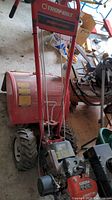 Full view of the red Troy-Bilt Econo Horse tiller with its large rear tires and red engine guard, showing brand and model labeling
