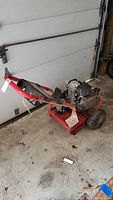 Full side view of red Troy-Bilt pressure washer with visible Honda GC160 engine and wheeled frame