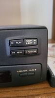 Close-up of front panel control buttons including Play, Stop/Eject, Rewind, Fast Forward, and Rec/OTR Pause