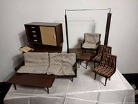 Full set showing sofa, side chairs, armchair, coffee table, cabinet, and hanging frame