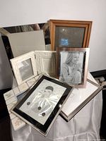 Overview of assorted picture frames stacked; various styles and sizes visible