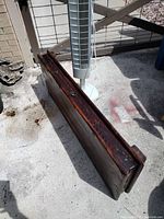 Solid wood coffee table top shown from side angle, revealing dark wood finish and thickness.