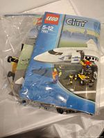 Instruction manual for LEGO City set 7893 encased in plastic bag with visible LEGO pieces inside.