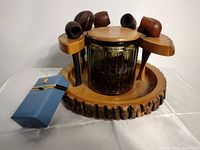 Overall view of wooden pipe rack with five pipes and blue cigarette case