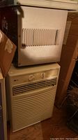 Photo of Mastercraft (top) and LG (bottom) window mount air conditioners showing front panels and sides.