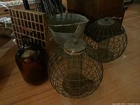 Photo showing wooden grate, brown glass jug, galvanized coal shuttle, and two metal bird feeders all grouped together.