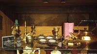 Photo of brass and copper items including candle holders, animal figurine, decorative plaque, copper kettle
