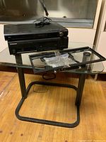 Pioneer 6-disc CD player on glass table along with the metal TV wall mount and mounting hardware in plastic bag
