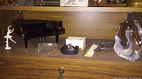 Ballerina on piano music box, crystal animal figurines, heart-shaped dish, and vintage dresser set brush, comb and mirror on wooden shelf