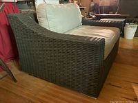 Front right angle view of oversized wicker patio chair with cushions