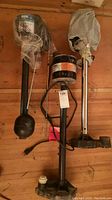 Three sump pumps laid flat showing motors and shafts with float switches, motors wrapped in plastic