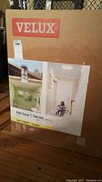 Photo of the Velux Sun Tunnel skylight boxed packaging showing branding and product image of installed skylight.