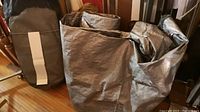Folded and rolled tarps showing different shades of grey and material types including one with zipper.