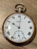 Front view showing white enamel dial with Roman numerals, subsidiary seconds, and blued steel hands