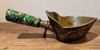 Side view showing brass scoop body with dragon engraving and enamel handle with colorful floral patterns.