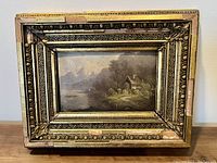 Frontal view of the antique oil painting in its ornate gold gilt wood frame showing the full artwork and detailed frame design.