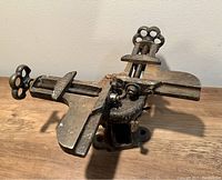 Full view of the heavy cast iron vintage Stanley picture frame corner vice showing two hand screw clamps and the general condition of the tool.