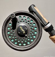 Top view showing Rimfly fly fishing reel attached to the rod, reel is black with circular perforations and labeled Rimfly