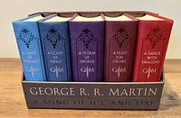 Five hardcover books in a leather cloth-bound boxed set of George R R Martin's A Song of Ice and Fire series.