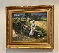 Full front view of oil painting showing woman seated near stone bridge in a natural landscape, framed in gold gilt wood frame.