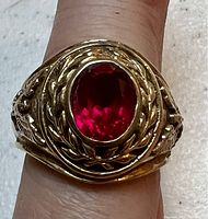 Top view of vintage sterling 925 ring showing large oval red stone and detailed military style engravings around stone