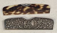 Photo showing the silverplated comb with tortoiseshell-like pattern placed above the ornately engraved silverplated case with figures and floral designs.