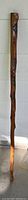 Full length view of the vintage walking stick showing the carved wood and painted inlays.