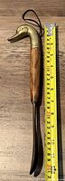 Full length photo showing the entire shoehorn next to a measuring tape, approximately 12 inches long.