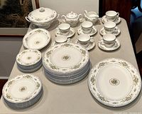 Full set of Wedgwood Petersham dinnerware laid out on table including plates, cups, saucers, cream and sugar, and tureen.