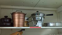 Shelf with copper double boiler with porcelain insert, metal pail, camping chafing dishes and hammered chafing dish
