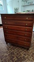 Front view of vintage Willet cherry dresser with six drawers, brass round pulls, showing overall wood finish and wear.