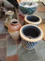 Photo of woven planters and green plastic planters on tiled floor
