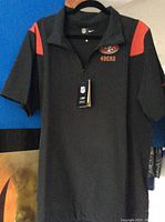 Front view of black Nike 49ers coach shirt with red accents on shoulders, showing 49ers logo embroidered on chest and Nike half-zip collar.