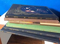 Stack of 6 books showing decorative spines and titles including The Enchanted World series and Australian World Heritage.