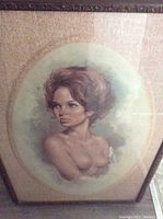 Frontal view of the framed vintage semi-nude portrait painting under glass showing the woman's upper body and detailed face with textured background.