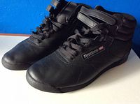Pair of black high top Reebok shoes showing side angle and lace details.